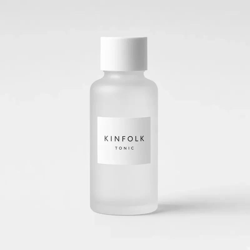 Frosted glass bottle with a white screw cap and a label reading Kinfolk tonic