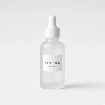 Frosted glass dropper bottle with a white label reading Kinfolk serum