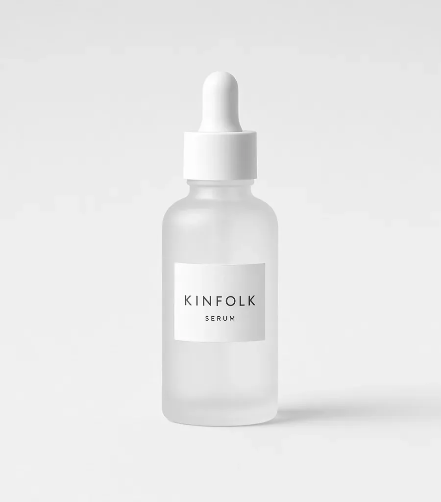 Frosted glass dropper bottle with a white label reading Kinfolk serum