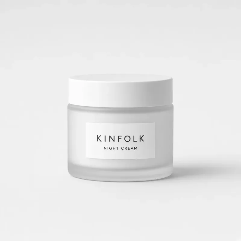 Frosted glass jar with a white lid and a label reading Kinfolk night cream