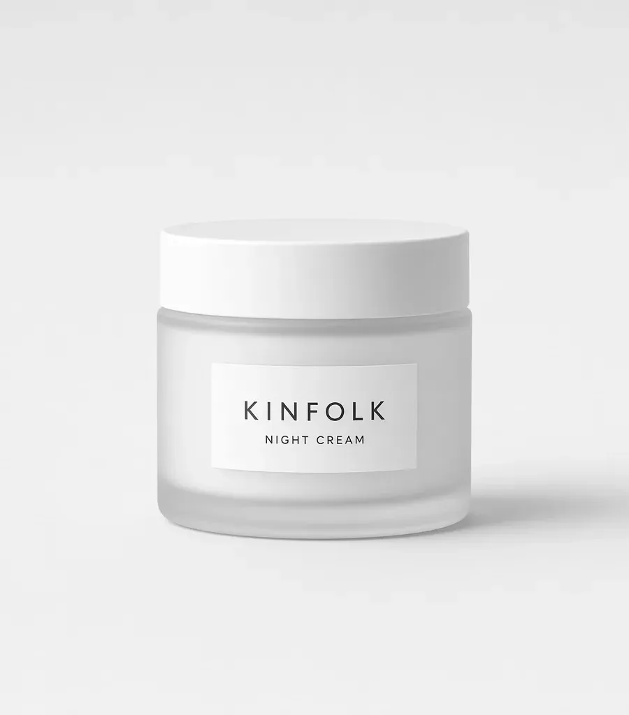Frosted glass jar with a white lid and a label reading Kinfolk night cream