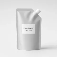 Aluminium refill pouch with a white spout and a label reading Kinfolk refill tonic