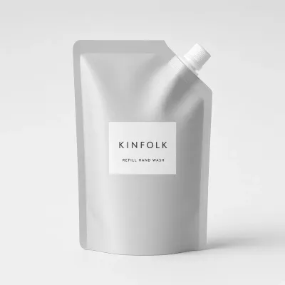 Aluminium refill pouch with a white spout and a label reading Kinfolk refill hand wash